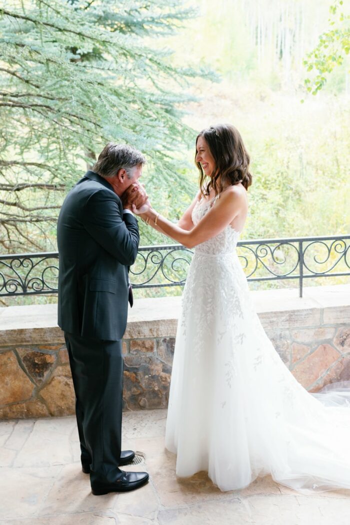 Father of the bride kissing hands of bride