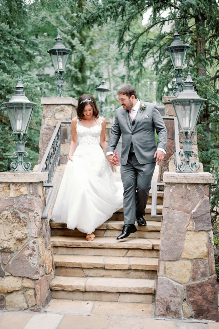 Bride and groom walking down the bridge at the Chateau in Beaver Creek