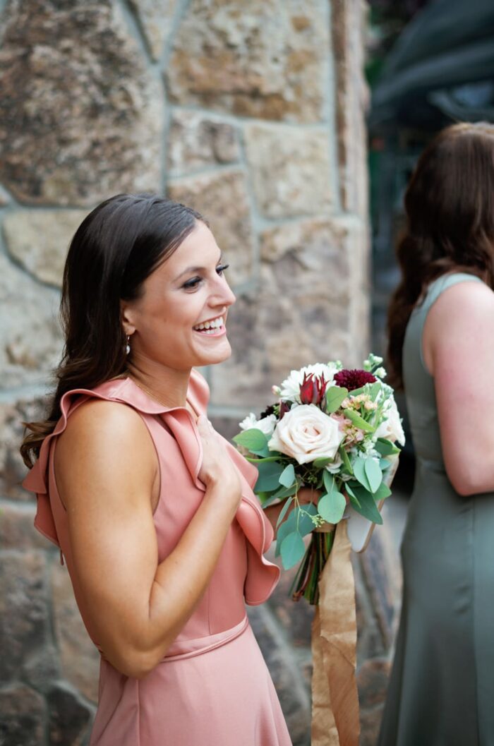 Bridesmaid in blush dress at first look with bride