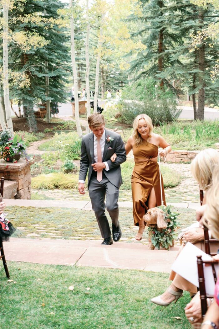 Maid of Honor walking dog ring bearer down ceremony aisle