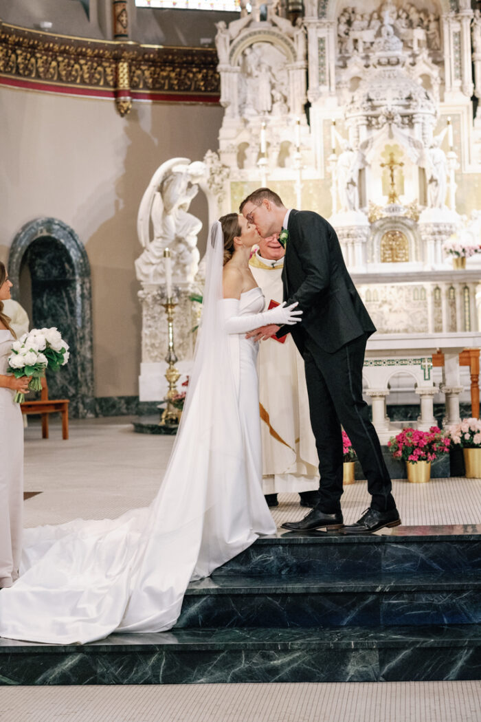 Bride and groom kissing at church wedding
