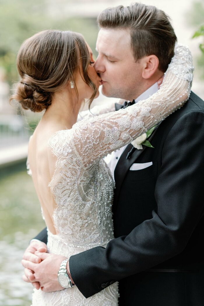 Bride and groom kissing each other at the Chicago Riverwalk