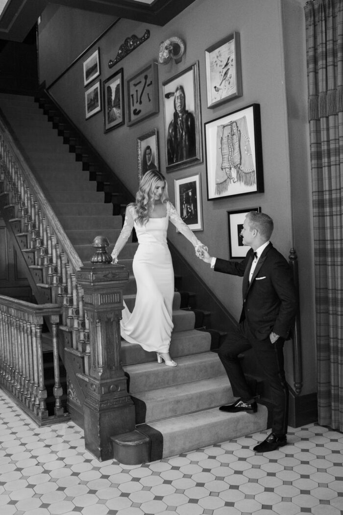 Bride and groom walking down stairs at Hotel Jerome in Aspen