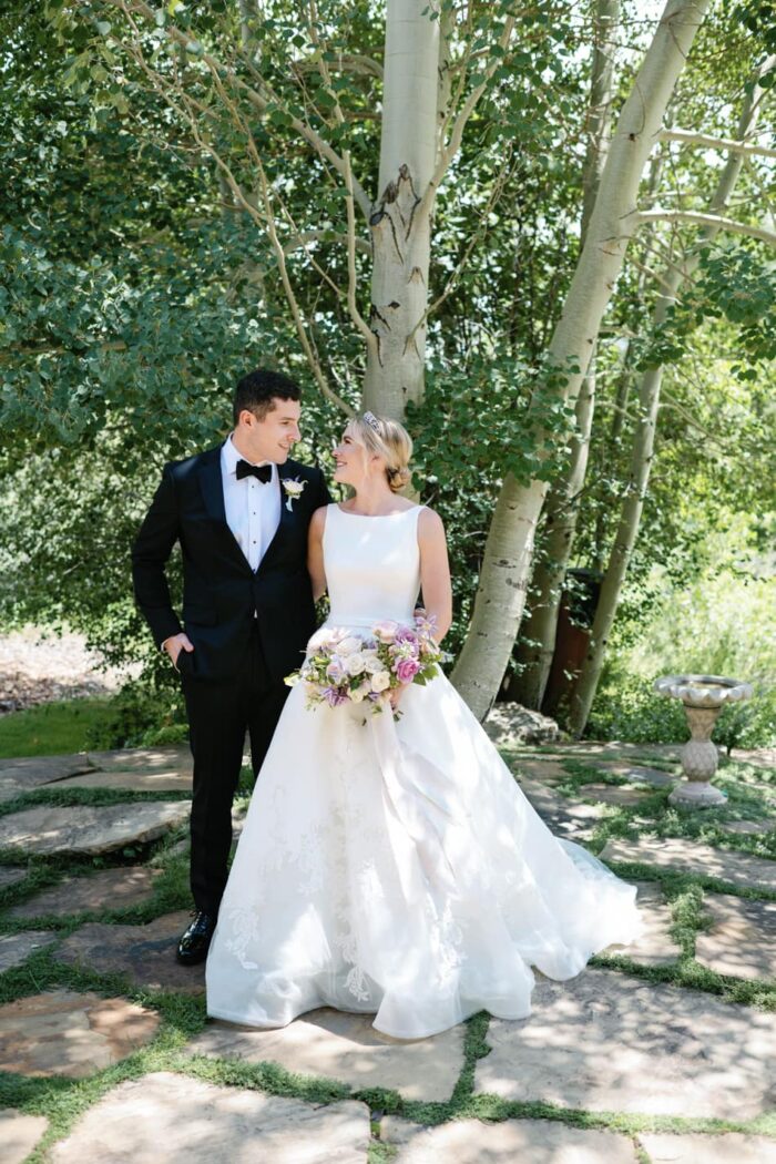Bride and groom standing under a tree in Aspen