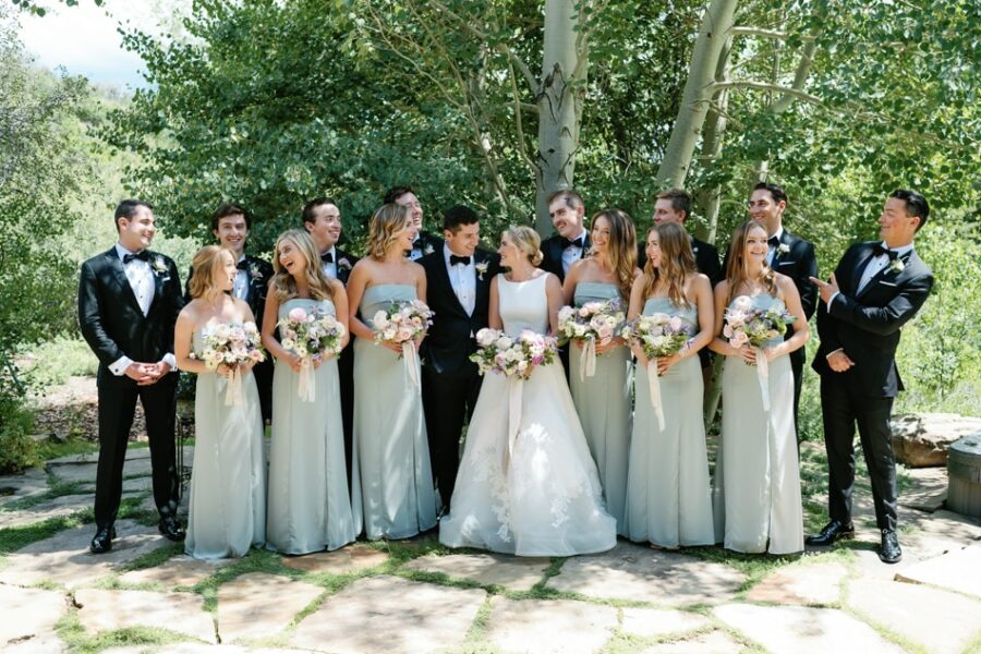 Bride and groom with wedding party standing under a tree in Aspen