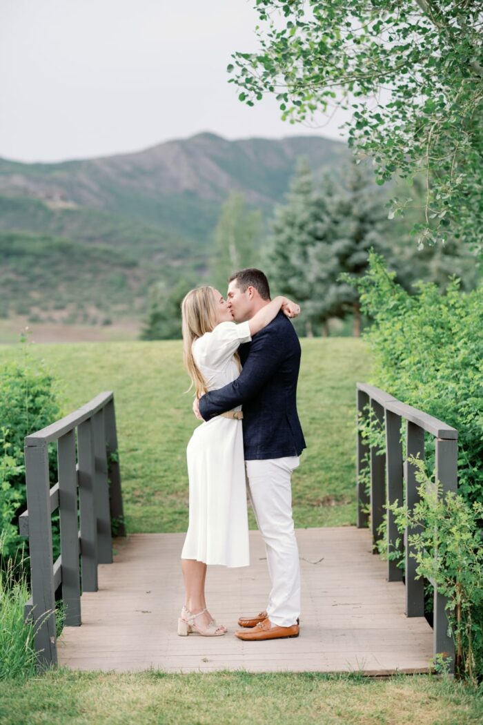 Bride and groom kissing on top of bridge in Aspen