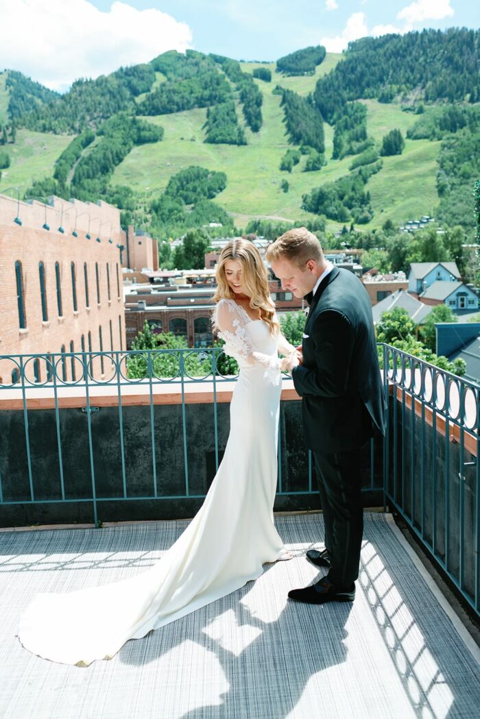 Groom admiring bride's dress during first look in Aspen