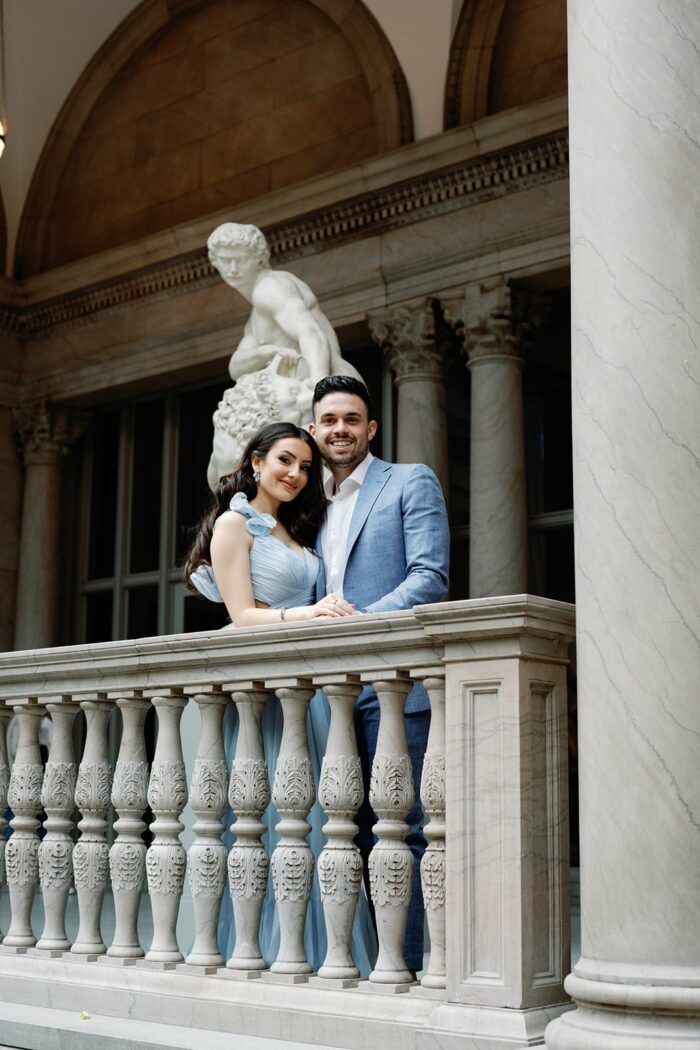 Bride and groom standing in front of a statue