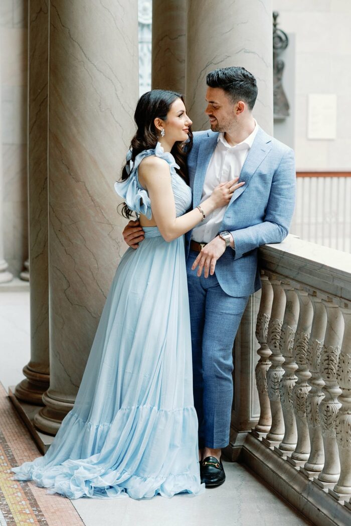 Bride and groom leaning on the stone fence at the Chicago Art Institute