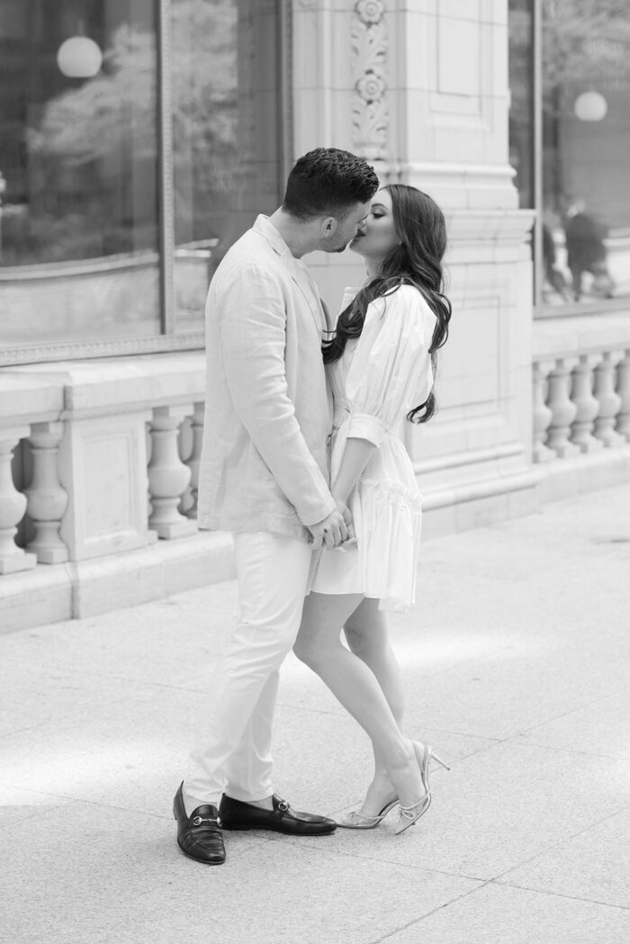 Bride and groom kissing in front of Wrigley Building